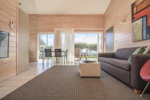 a living room with a couch and a table at Ohope Beach TOP 10 Holiday Park in Ohope Beach