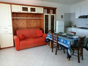 a living room with a red couch and a table at Appartamento di villa gesualda in Serrara Fontana