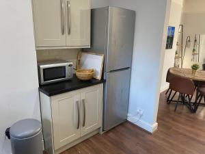 a kitchen with a stainless steel refrigerator and a table at Invicta Apartment in Ashford