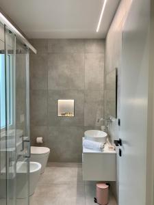 uma casa de banho com 2 lavatórios, uma banheira e um WC. em Golden apartments em Montesilvano