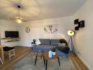 uma sala de estar com um sofá azul e uma televisão em La Serrisienne 5 - Val d'Europe - Disneyland Paris - 6 à 8 Personnes em Serris