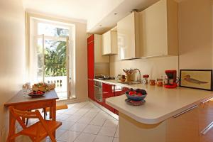 cocina con encimera, mesa y ventana en Magnifique appartement d'époque avec Vue Mer 4 personnes avec terrasse Le Port Nice en Niza