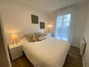 ein Schlafzimmer mit einem großen weißen Bett und einem Fenster in der Unterkunft La Serrisienne 5 - Val d'Europe - Disneyland Paris - 6 à 8 Personnes in Serris