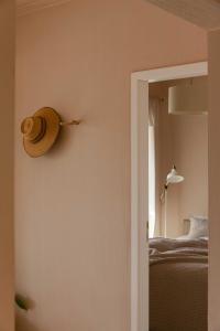 un sombrero colgado en una pared junto a una cama en Azenhas do Mar Roadside House en Colares