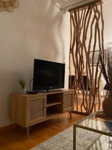 a television sitting on a cabinet in a living room at Saint Tropez Spacieux Appartement La Florida in Saint-Tropez