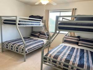 Cette chambre comprend 2 lits superposés et une fenêtre. dans l'établissement Cheerful Pool Home-Lowkey, 10min to Lake, Comfort, à Lake Havasu City