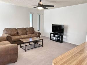 a living room with a couch and a flat screen tv at Cheerful Pool Home-Lowkey, 10min to Lake, Comfort in Lake Havasu City