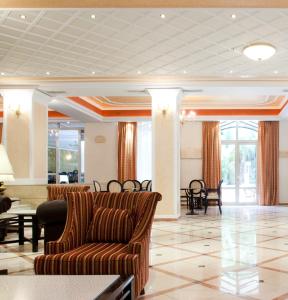 a lobby with a couch and a table and chairs at Achillion Palace in Rethymno