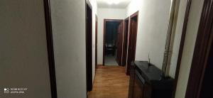 un couloir menant à une chambre avec une télévision et une porte dans l'établissement Apartamentos xistra, à Cangas del Narcea