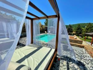 a bed in a tent next to a swimming pool at GardenLux Vrdnik in Vrdnik