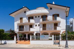 een wit gebouw met een bord ervoor bij B&B Sperlonga in Sperlonga