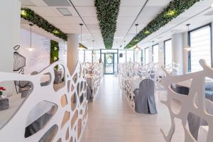 a dining room with white tables and chairs at Hotel Viadero in Noja