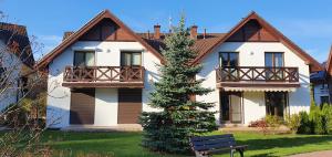 a house with a christmas tree in front of it at Apartament Kalimera in Żarnowska