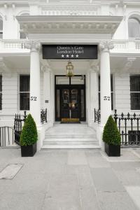 a front door of a white building with a sign on it at The Queens Gate Hotel in London