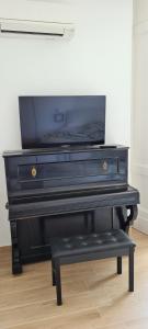 a black piano with a bench in a room at SINFONIA SUITES CATANIA in Catania