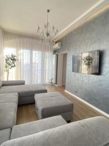 una sala de estar con sofás y una lámpara de araña. en Apartment Lana, en Baška Voda