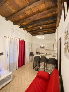 sala de estar con sofá rojo y cocina en Casa medievale Il Rifugio di Olimpia, en Viterbo