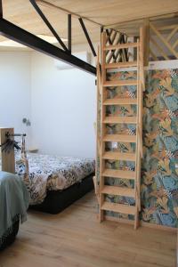 een slaapkamer met een stapelbed en een ladder bij Maison Ti Havre avec jardin privé dans village de pêcheurs à Brem sur mer ! in Brem-Sur-Mer