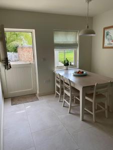 a kitchen with a table and chairs and a window at Grooms Cottage by Sheriff Hutton Castle near York in Sheriff Hutton