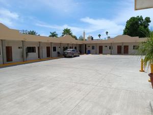 un grand parking en face d'un bâtiment dans l'établissement Hotel Romo, à Los Mochis