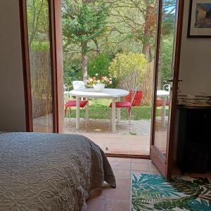 a bedroom with a table and a table and chairs outside at Suite avec jardin entre Aix en Provence, Luberon et Verdon in Peyrolles-en-Provence