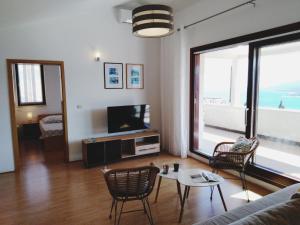 een woonkamer met een bank en een tv bij Sea View K Loft in Rabac
