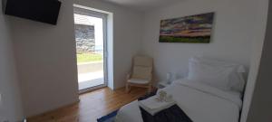 a small room with a bed and a window at House Nobrega of Madeira in Arco da Calheta