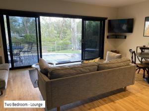 ein Wohnzimmer mit einem Sofa und einer Glasschiebetür in der Unterkunft Adelphi Apartments 3 or 3A - Downstairs 2 Bedroom or Upstairs King Studio with Balcony in Echuca