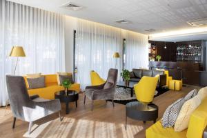 a living room with yellow and gray furniture at Best Western Plus Thionville Centre in Thionville