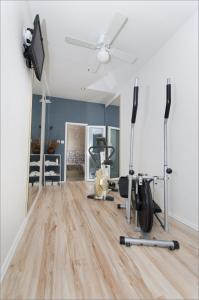 a room with a gym with exercise equipment and a ceiling fan at Villa Bougenvilia Tomas in Tučepi