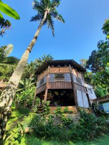 ein Haus mit einer Palme davor in der Unterkunft Hostel Casa Conduru in Itacaré