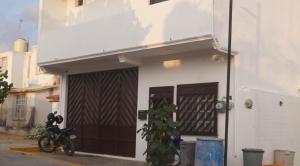 a motorcycle parked in front of a building with a garage at TMX HOSTAL in Puerto Escondido