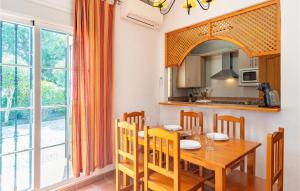 kuchnia i jadalnia z drewnianym stołem i krzesłami w obiekcie Cozy Apartment In Alcaucín With Wifi w mieście Alcaucín