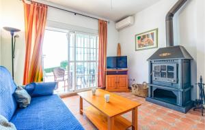 sala de estar con sofá azul y estufa de leña en 1 Bedroom Stunning Apartment In Alcaucn, en Alcaucín