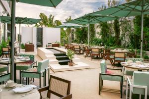 un ristorante all'aperto con tavoli, sedie e ombrelloni di ette luxury hotel & spa a Orlando