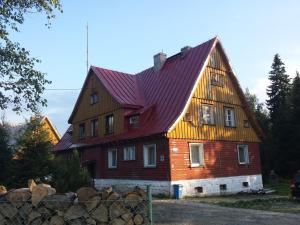 una gran casa de madera con techo rojo en Strażnica Pod Lasem, en Lasowka