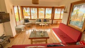 a living room with a red couch and a table at Terrazas Iguana in Máncora