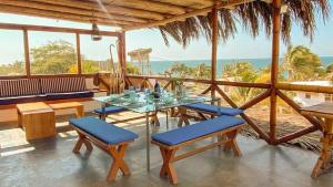 een eetkamer met een tafel en stoelen en de oceaan bij Terrazas Iguana in Máncora