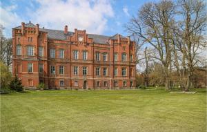 a large red brick building with a large grass yard at Awesome Apartment In Krakow Am See With Kitchen in Krakow am See