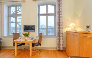 a dining room with a table and chairs and windows at Cozy Apartment In Krakow Am See With Kitchenette in Krakow am See