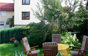 three chairs and a table in a yard at 2 Bedroom Lovely Apartment In Nahetal-waldau in Hinternah