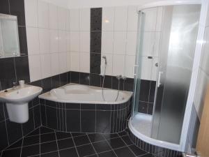 ein Badezimmer mit einer Badewanne und einem Waschbecken in der Unterkunft Motel Madona in Banská Bystrica