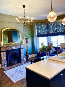 a living room with a fireplace and blue walls at Lletty by Orenda-Luxe in Llandudno