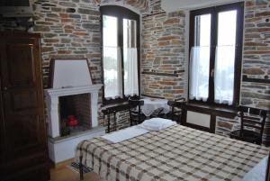 ein Schlafzimmer mit einem Bett und einer Ziegelwand in der Unterkunft Paris & Eleni in Áfissos