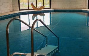 a swimming pool with a chair in the water at Beautiful Home In Gerolstein With Wifi in Gerolstein