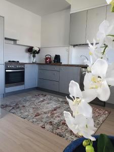 una cocina con flores blancas en el medio en Senhora da Guia Boutique Apartment en Vila do Conde