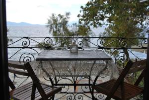 una mesa en un balcón con vistas al agua en Paris & Eleni, en Áfissos