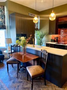 a kitchen with a wooden table with chairs and a counter at Lletty by Orenda-Luxe in Llandudno