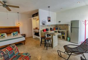 Les Suites Calle 2 by Galian في تولوم: مطبخ وغرفة معيشة مع أريكة وثلاجة