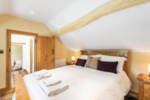 una camera da letto con un grande letto bianco con asciugamani di Pen Y Bont a Llangollen
